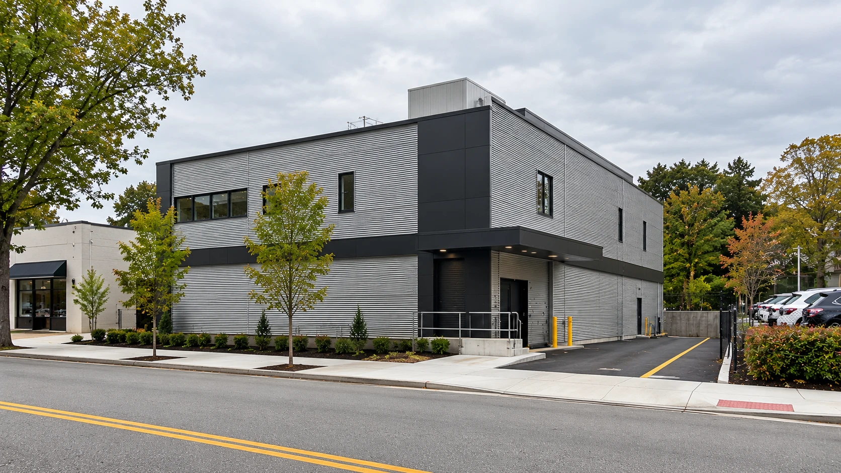 Illustrative image of a new two-storey storage building with metal siding and a loading dock on a corner lot in Great Neck