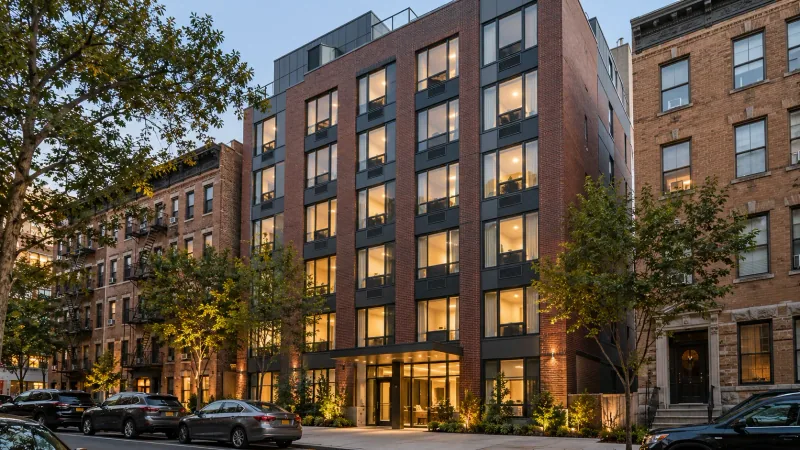Illustrative image of a new mid-rise brick apartment building on a city street