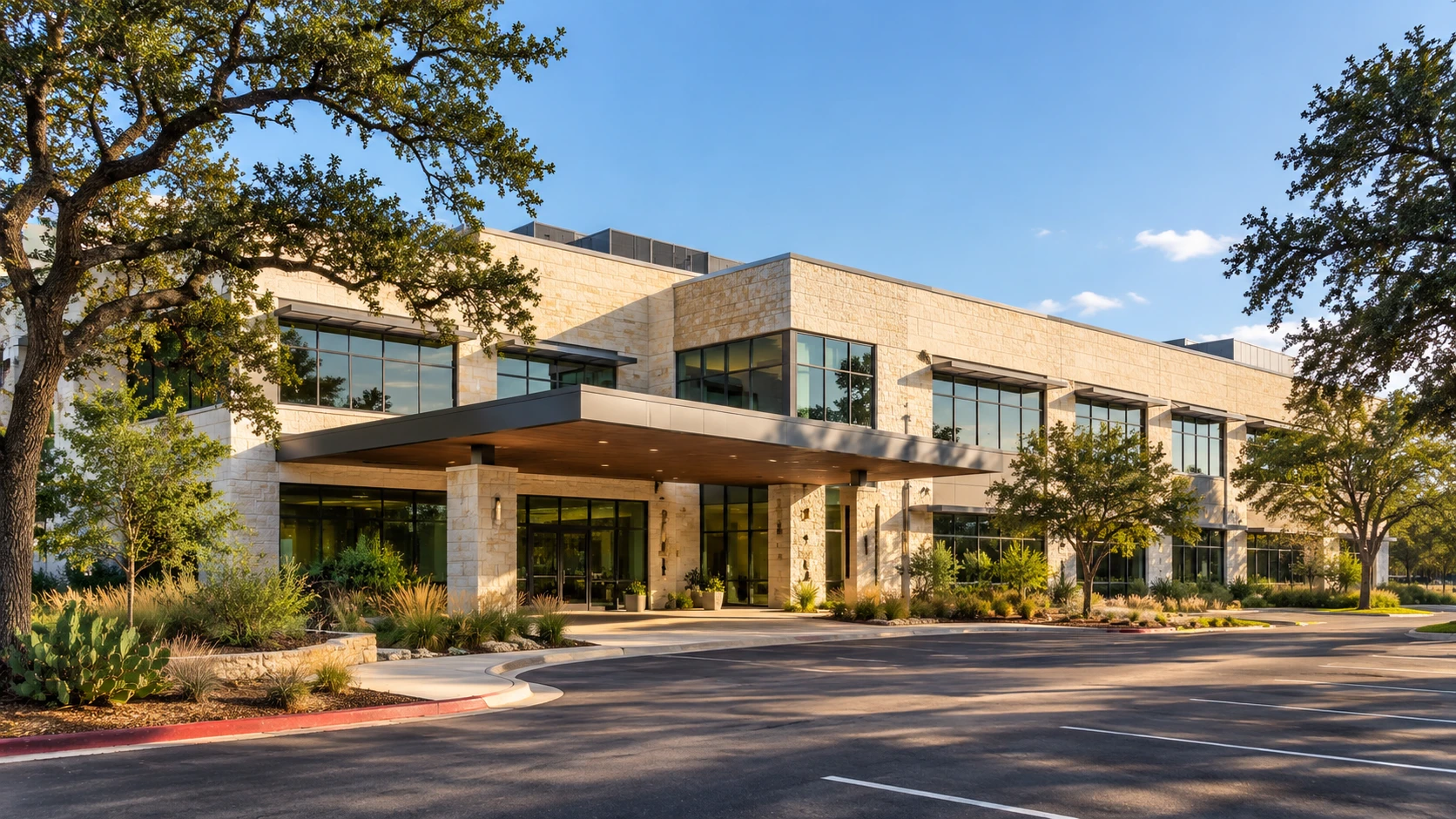 Illustrative image of a two-storey limestone and glass medical office building with a covered entrance, live oak trees and native landscaping beside a parking lot